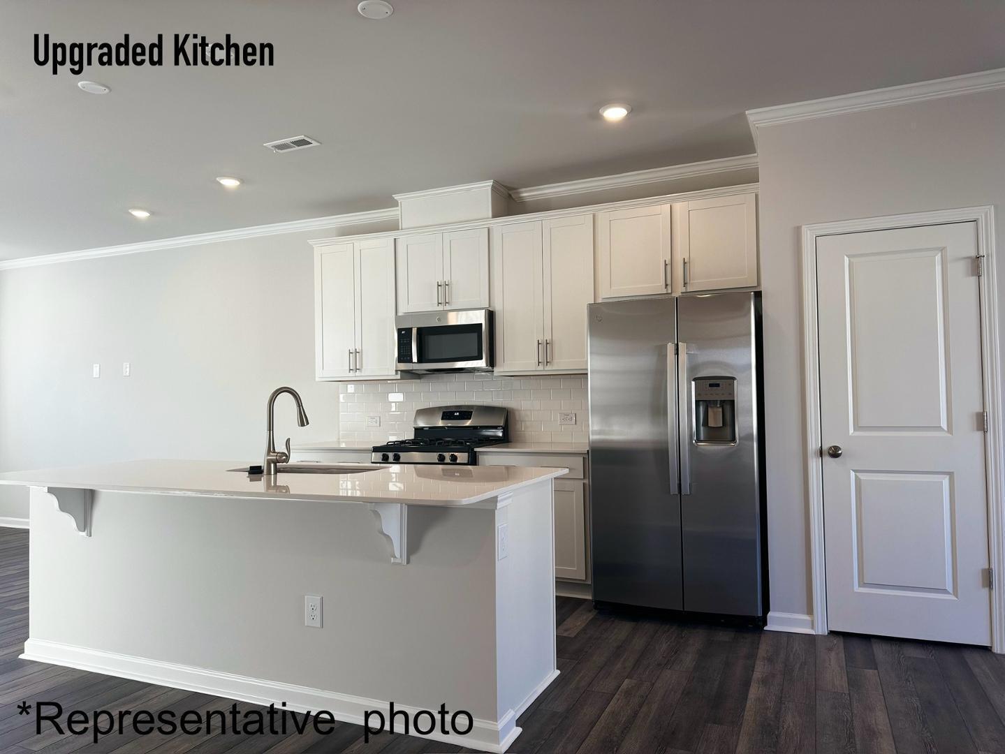 168 Aster Bloom Lane Raleigh, NC 27610 - Photo 10 of 38 a kitchen with stainless steel appliances granite countertop a refrigerator a sink a stove a microwave and white cabinets with wooden floor