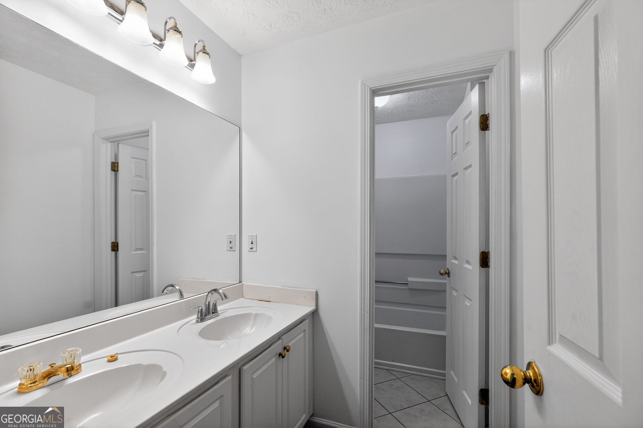 3960 East Saddle Ridge Drive Lithonia, GA 30038 - Photo 20 of 36 a bathroom with a sink double vanity and a mirror