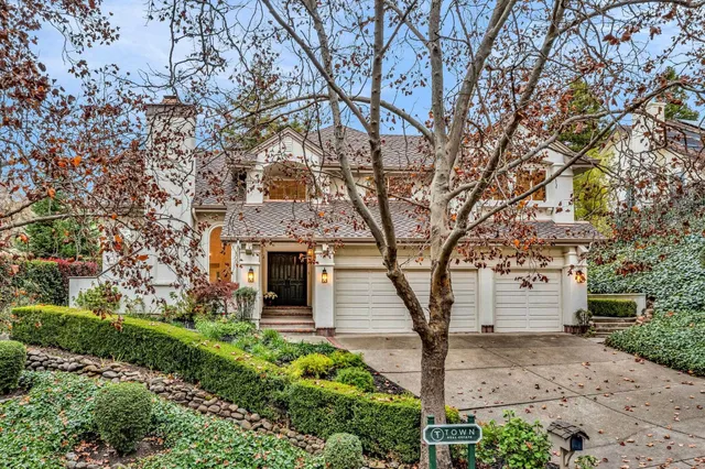 a front view of a house with a tree