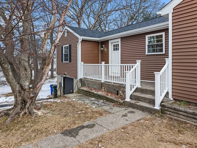 a view of a house with a yard and wooden fence