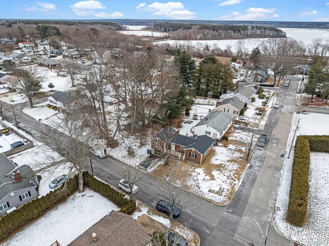a kitchen with stainless steel appliances granite countertop a refrigerator a sink dishwasher a stove and white cabinets with wooden floor