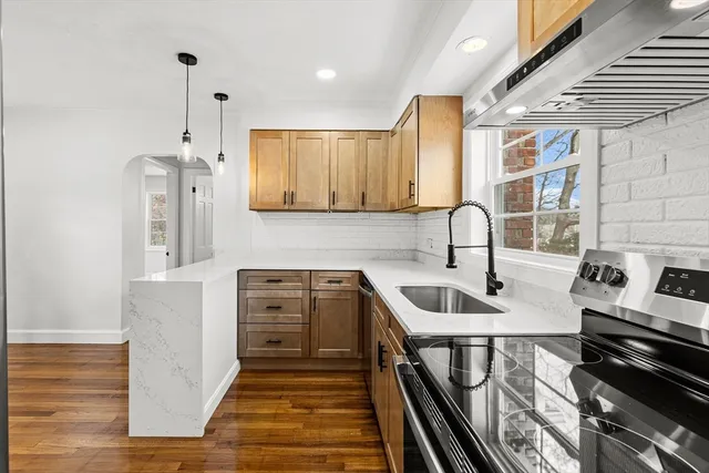a kitchen with stainless steel appliances granite countertop a sink cabinets and wooden floor
