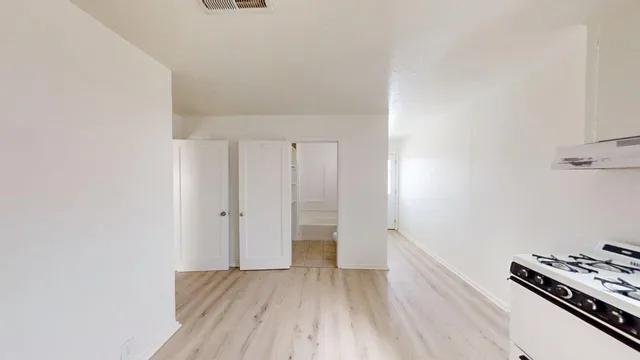 a view of an empty room with wooden floor