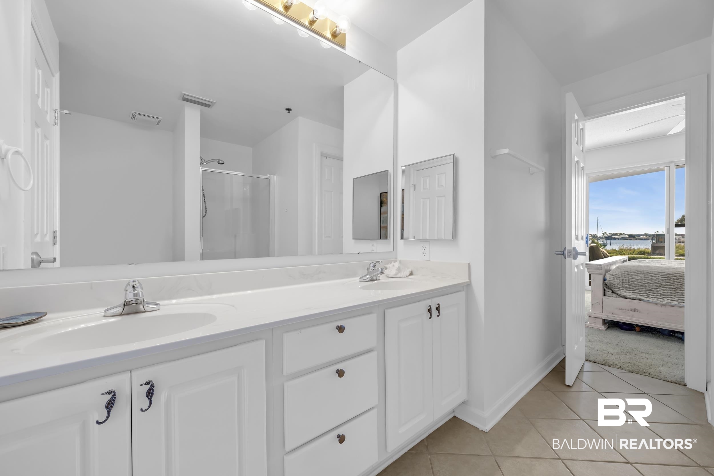 27282 Canal Road, Unit 104 Orange Beach, AL 36561 - Photo 36 of 79 Ensuite bathroom featuring a stall shower, light tile patterned floors, and double vanity