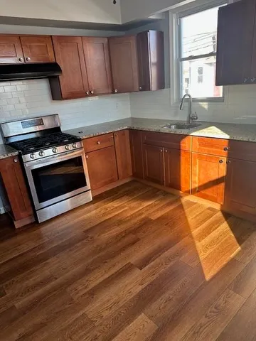 a kitchen with wooden cabinets and a stove top oven