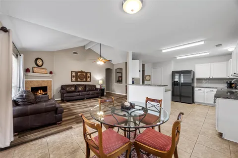a living room with furniture a fireplace and kitchen view