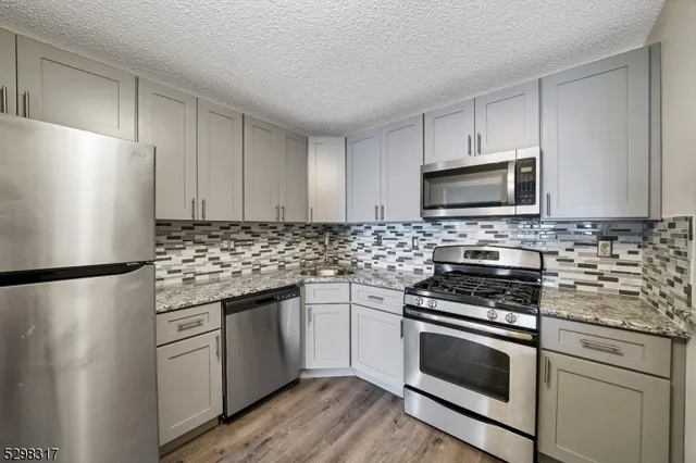 a kitchen with stainless steel appliances a refrigerator stove and microwave