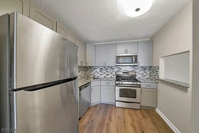 a kitchen with a refrigerator and a stove top oven