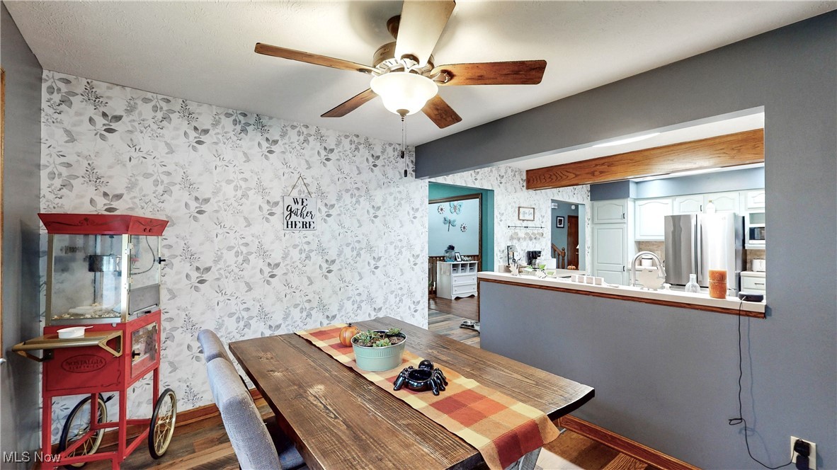 3123 Clearview Road Ravenna, OH 44266 - Photo 23 of 44 Dining area featuring wallpapered walls, ceiling fan, and wood finished floors