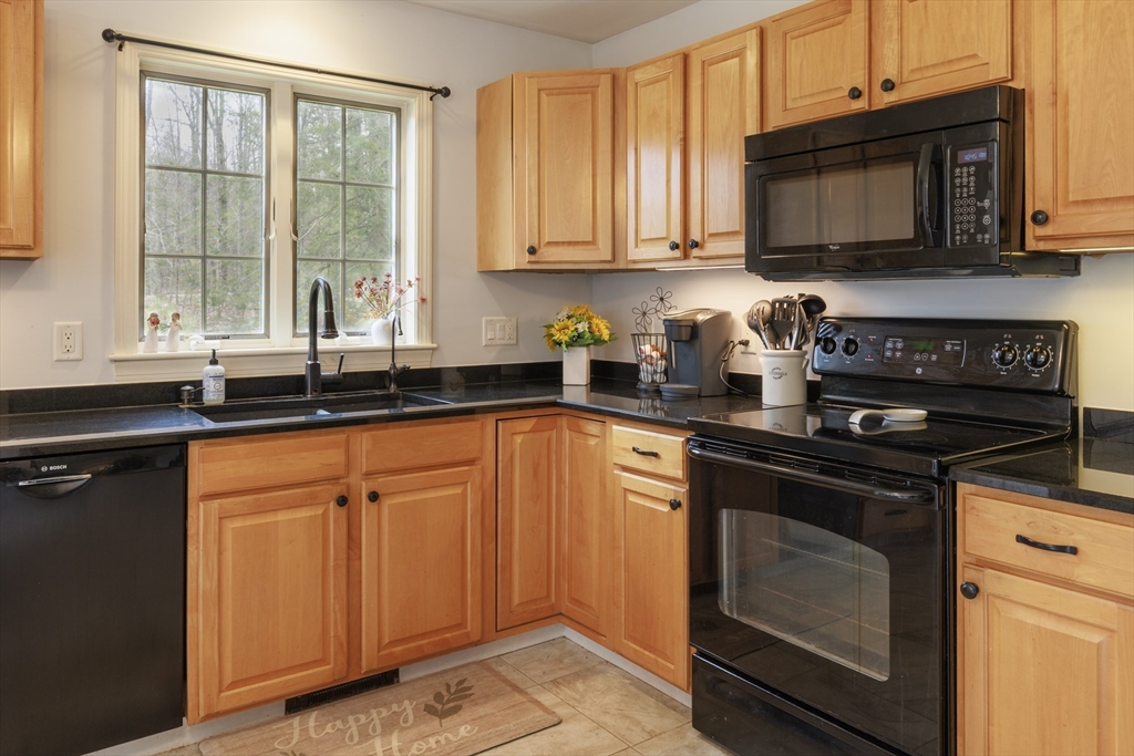 501 Reservoir Road Deering, NH 03244 - Photo 5 of 40 a kitchen with stainless steel appliances granite countertop a stove a sink and a microwave