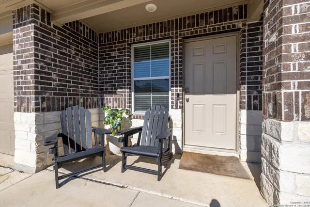 a view of two chairs and a table in the patio