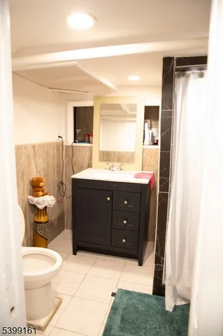 a spacious bathroom with a granite countertop sink a toilet and a mirror