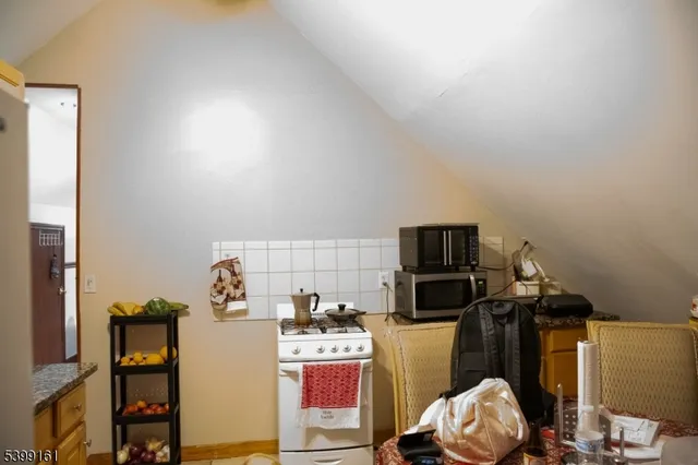 a view of a kitchen with fridge and workspace