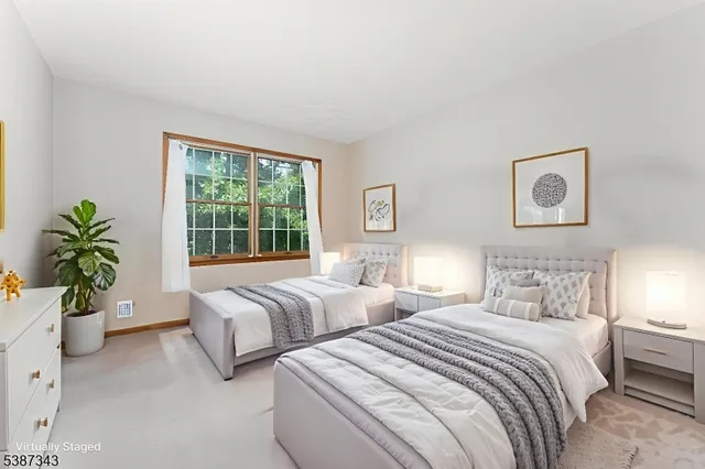 a bedroom with two beds and potted plant