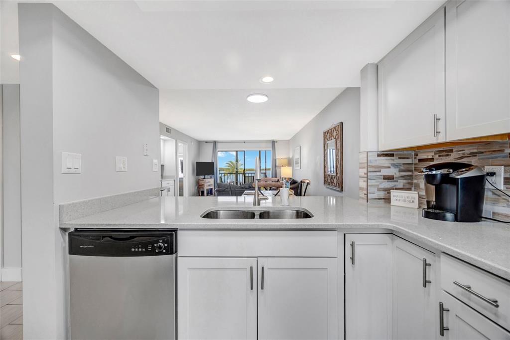 4620 Bay Boulevard, Unit 1117 Port Richey, FL 34668 - Photo 12 of 37 a kitchen with stainless steel appliances a sink a stove a refrigerator cabinets and a counter top space