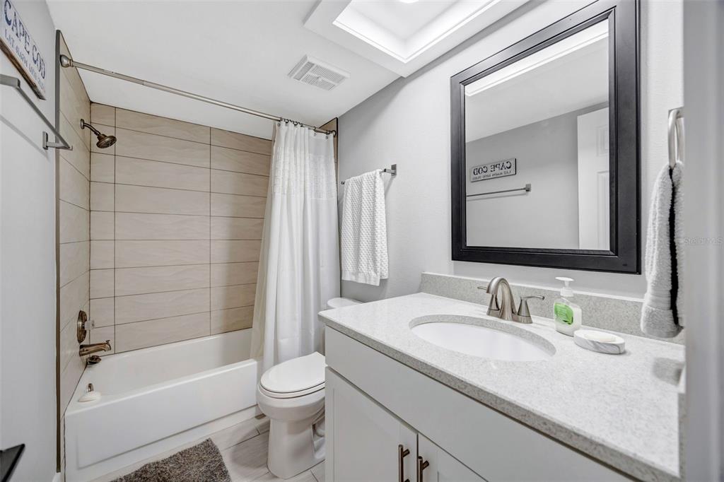4620 Bay Boulevard, Unit 1117 Port Richey, FL 34668 - Photo 21 of 37 a bathroom with a granite countertop sink toilet and shower