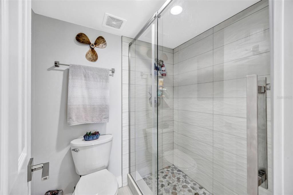 4620 Bay Boulevard, Unit 1117 Port Richey, FL 34668 - Photo 28 of 37 a bathroom with a shower a toilet and a sink
