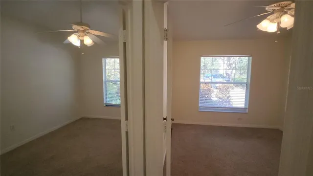 a view of a room with a ceiling fan and a hardwood floor