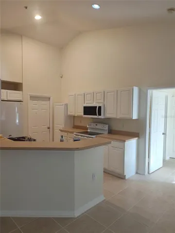 a kitchen with granite countertop white cabinets and stainless steel appliances