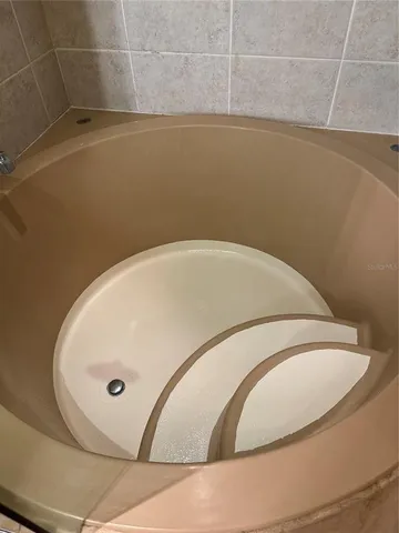 a bathroom with a tub a sink and mirror