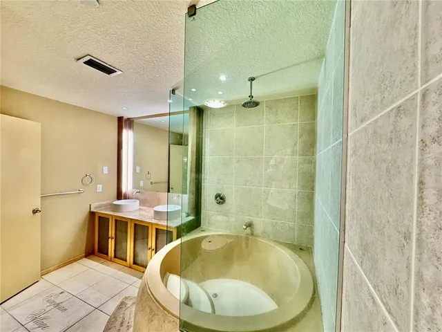 a bathroom with a tub sink and mirror