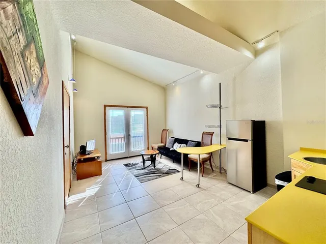a living room with furniture a rug and kitchen view
