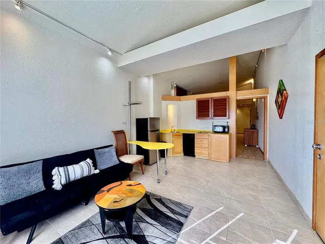 a bedroom with a bed and dresser with wooden floor