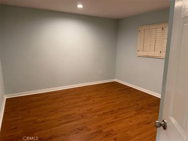 an empty room with wooden floor & cabinet