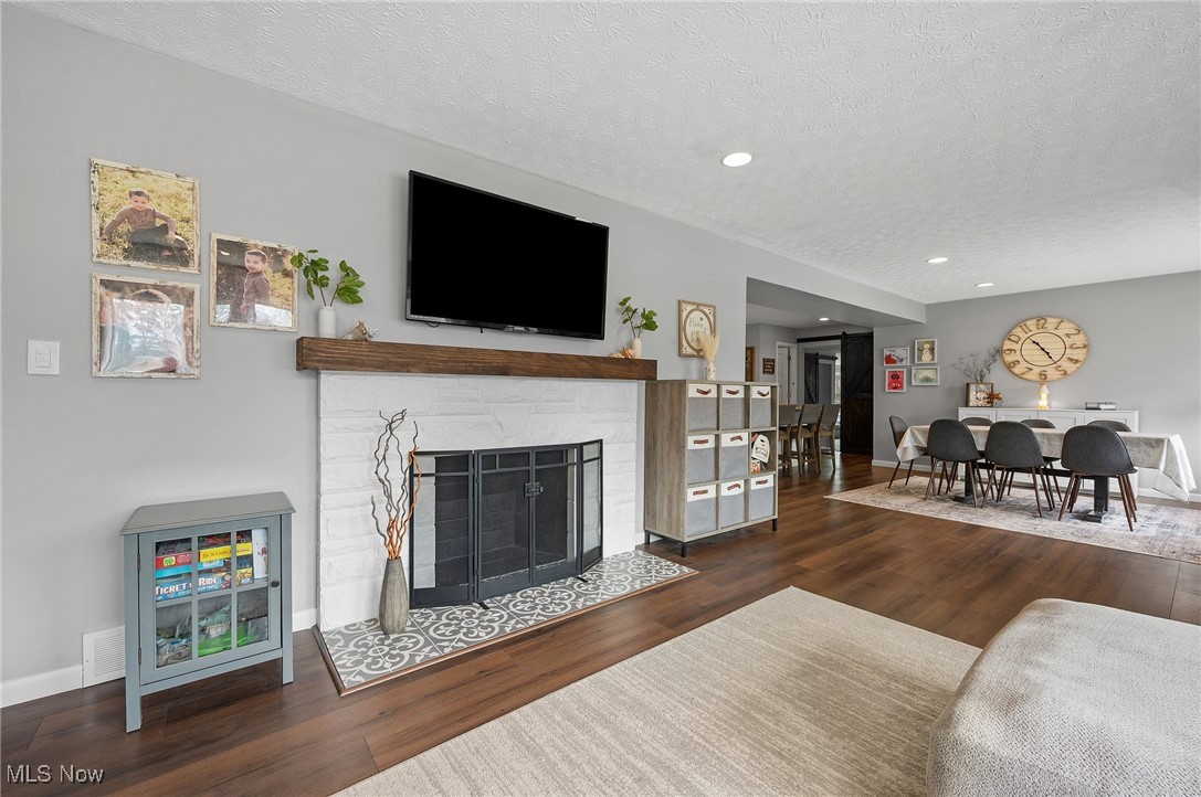 87 Kenridge Road Akron, OH 44333 - Photo 6 of 48 Living room featuring a textured ceiling, wood finished floors, visible vents, and baseboards