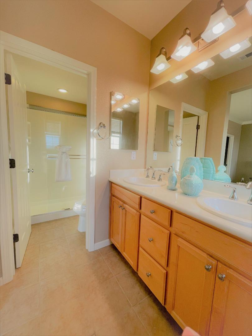 5150 Fioli Loop San Ramon, CA 94582 - Photo 24 of 38 a spacious bathroom with a granite countertop sink mirror and a shower