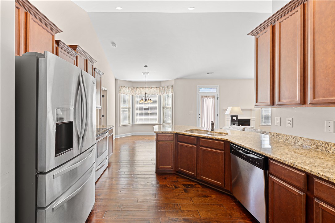 409 Coldstream Court Seneca, SC 29678 - Photo 16 of 40 An inviting kitchen with rich wood flooring flows into a bright living space.