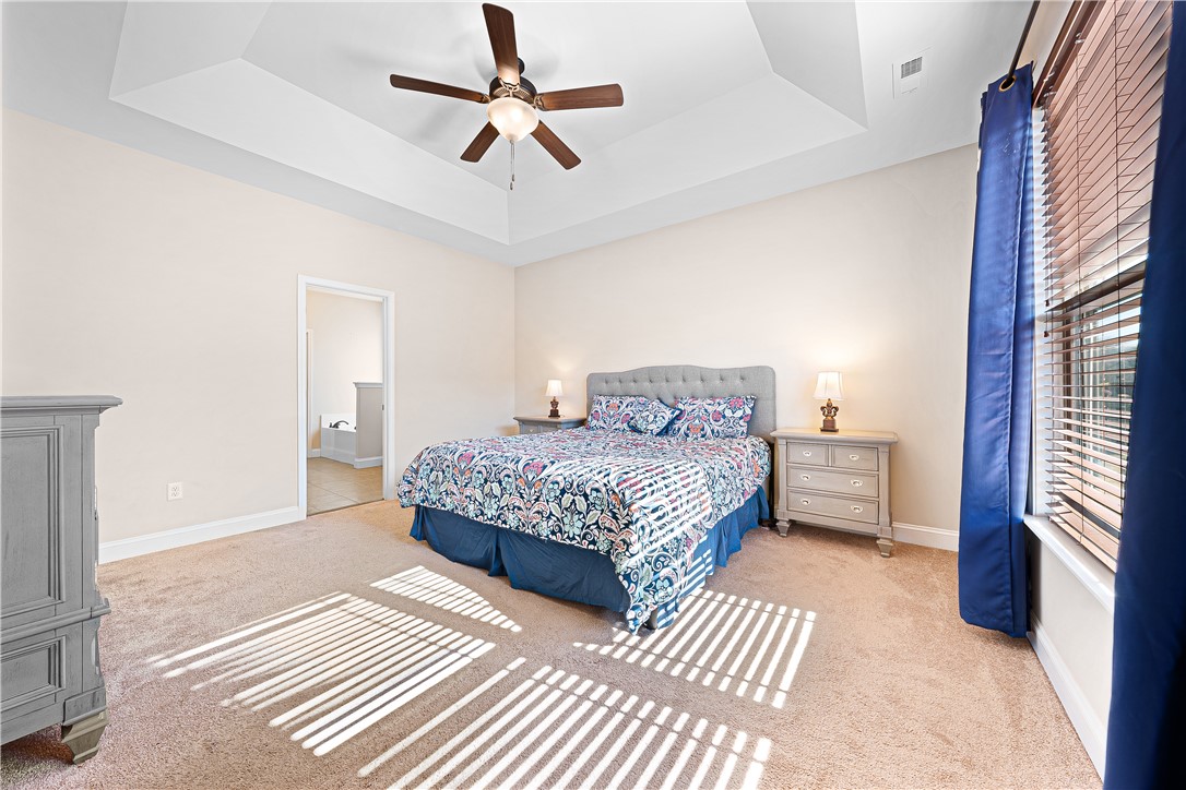 409 Coldstream Court Seneca, SC 29678 - Photo 18 of 40 This spacious primary bedroom features soft carpeting, a tray ceiling, and an adjoining bathroom.
