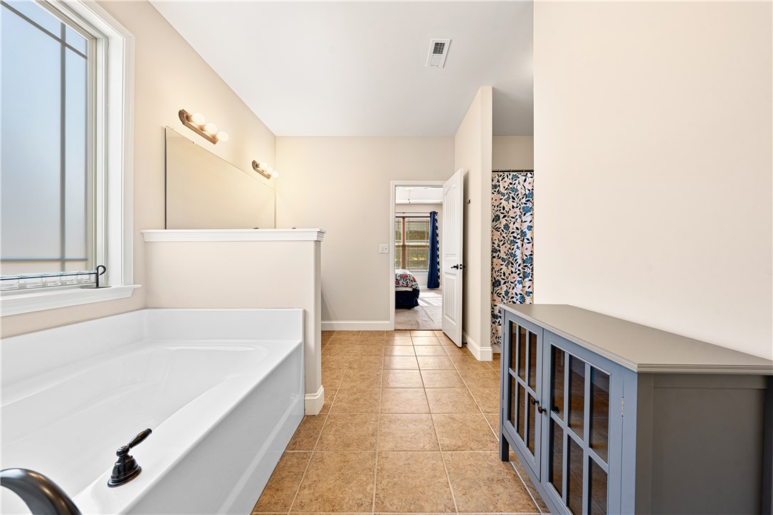 409 Coldstream Court Seneca, SC 29678 - Photo 25 of 40 This primary bathroom features an inviting soaking tub and tiled flooring.
