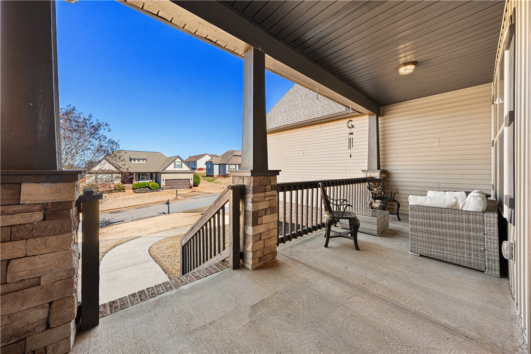 409 Coldstream Court Seneca, SC 29678 - Photo 5 of 40 This inviting porch, featuring stone accents, offers a serene outdoor space with community views.