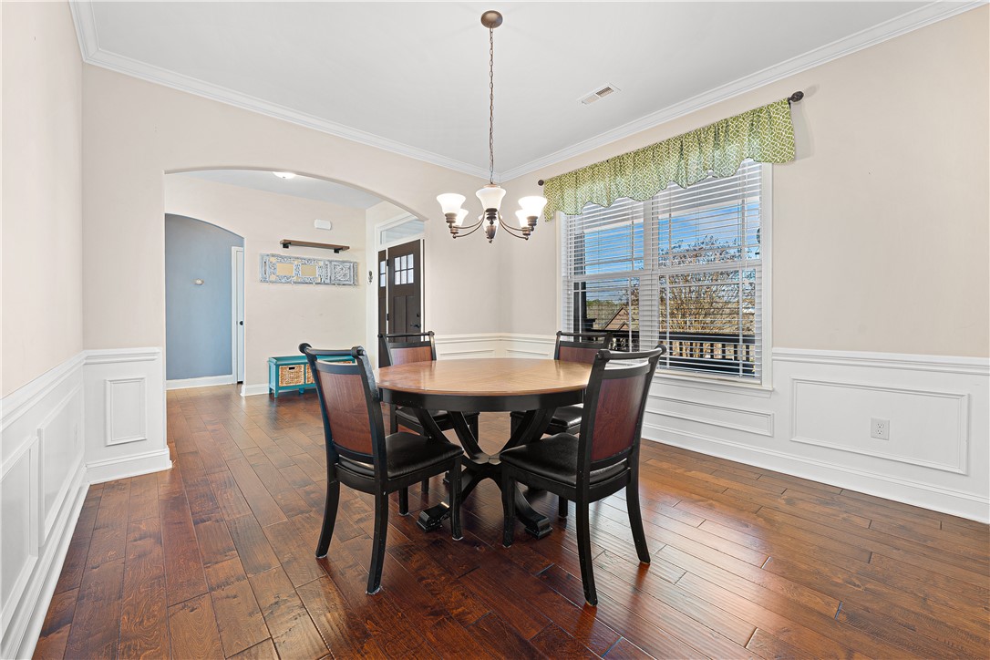 409 Coldstream Court Seneca, SC 29678 - Photo 10 of 40 This bright dining area features elegant hardwood flooring, wainscoting, and crown molding.