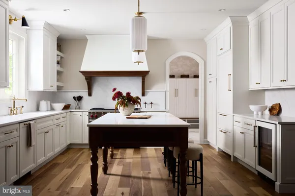 a kitchen with stainless steel appliances a table chairs and a refrigerator