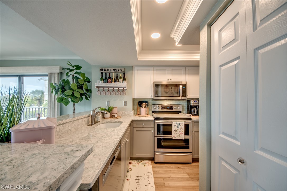 16611 Stringfellow Road, Unit 203 Bokeelia, FL 33922 - Photo 15 of 48 a kitchen with stainless steel appliances granite countertop a stove a sink and a refrigerator