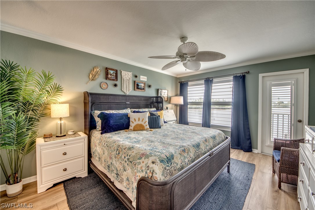 16611 Stringfellow Road, Unit 203 Bokeelia, FL 33922 - Photo 20 of 48 a bedroom with a large bed and a chandelier