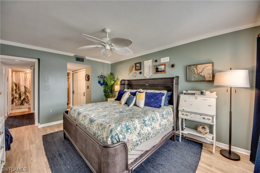 16611 Stringfellow Road, Unit 203 Bokeelia, FL 33922 - Photo 22 of 48 a bedroom with a large bed a chandelier and dresser