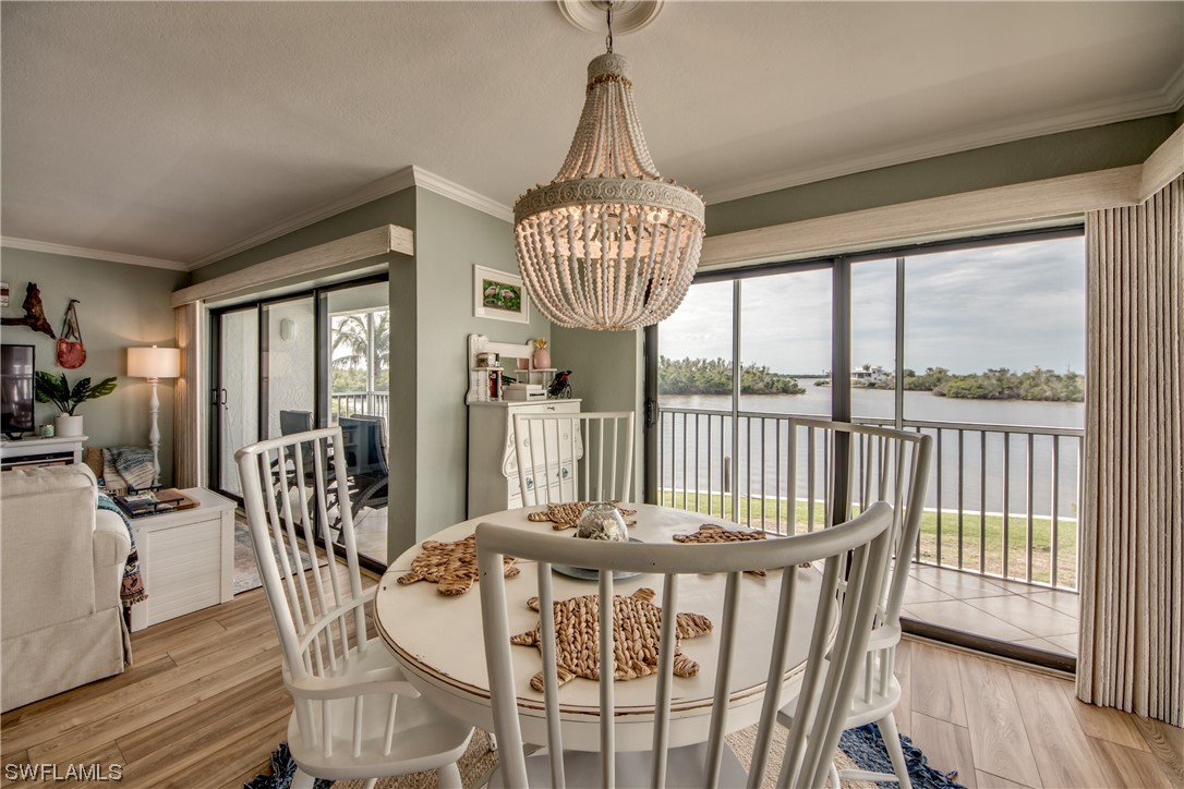 16611 Stringfellow Road, Unit 203 Bokeelia, FL 33922 - Photo 10 of 48 a view of a dining room with furniture window and wooden floor