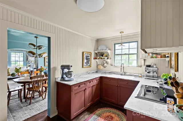 a kitchen with granite countertop a sink stove and cabinets