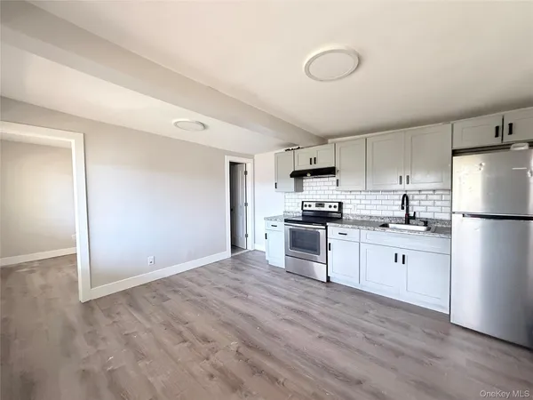 a kitchen with white cabinets and white appliances