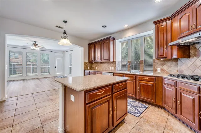 a open kitchen with granite countertop a sink cabinets and stainless steel appliances