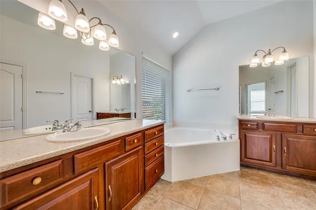 a spacious bathroom with a granite countertop tub sink and mirror