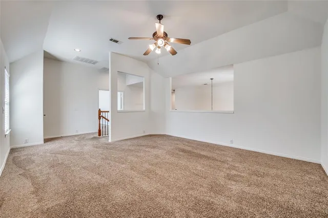 an empty room with windows and a ceiling fan