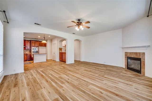 a view of an empty room with a fireplace and a window