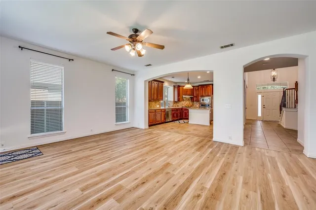 a view of a livingroom with wooden floor and a kitchen