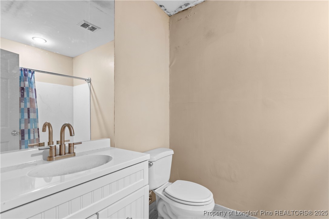 124 Racquet Lane Pinehurst, NC 28374 - Photo 17 of 25 a bathroom with a sink a toilet and mirror