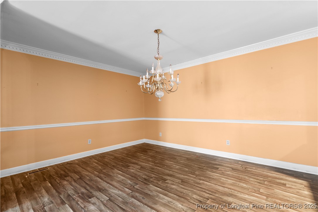 124 Racquet Lane Pinehurst, NC 28374 - Photo 5 of 25 a view of a room with wooden floor and chandelier
