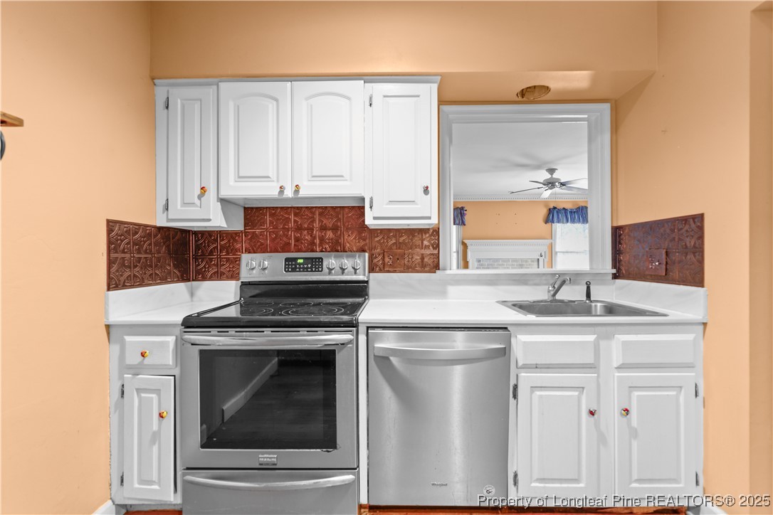 124 Racquet Lane Pinehurst, NC 28374 - Photo 10 of 25 a kitchen with white cabinets and appliances